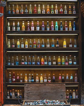 A vibrant display of various bottled drinks arranged neatly on a wooden shelf.