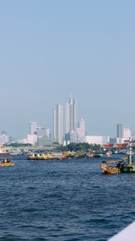 Explore the iconic Bangkok skyline and bustling river traffic, capturing urban vibrancy.