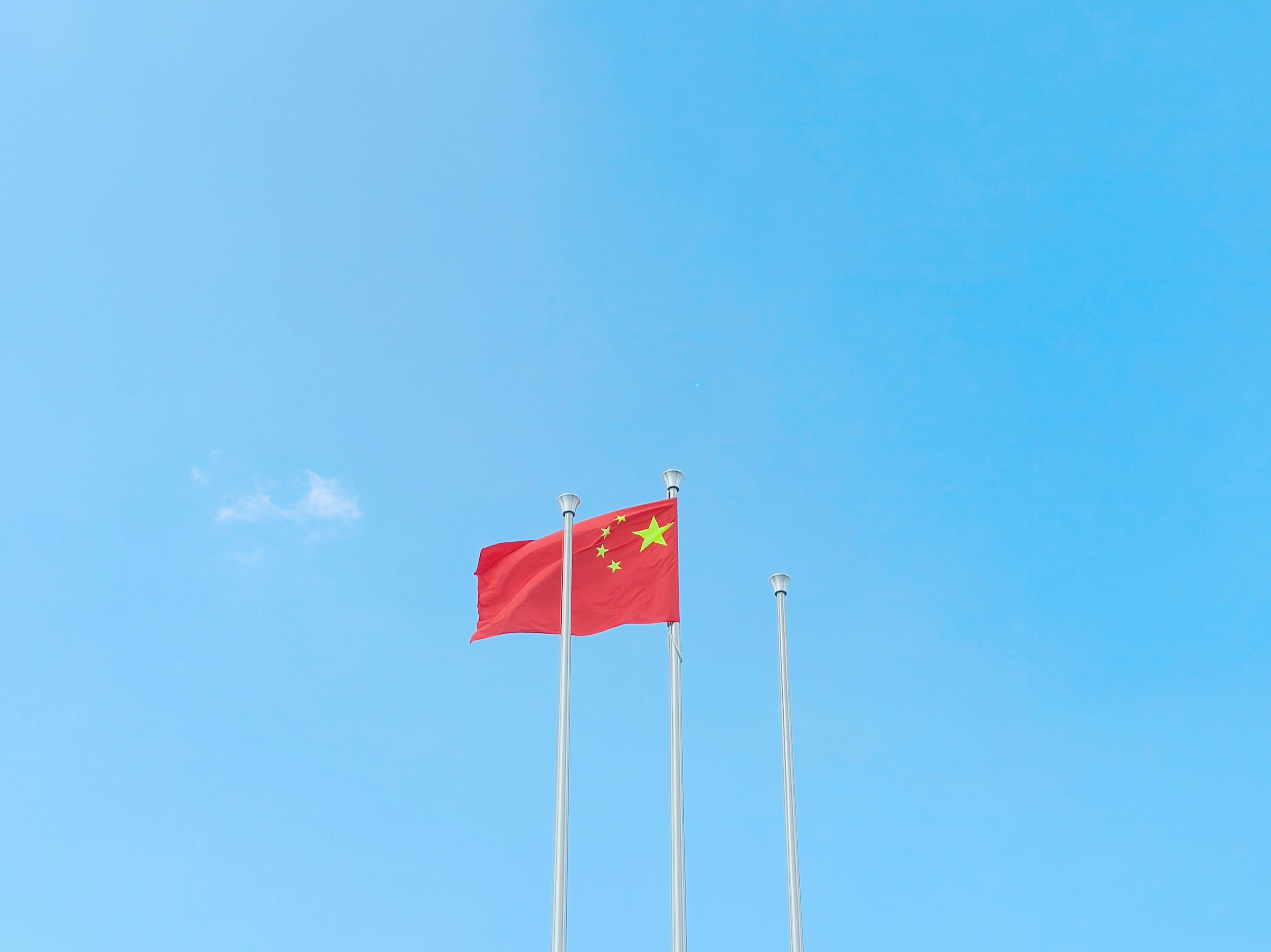 Vibrant Chinese flag waving on a sunny day, symbolizing unity and patriotism.