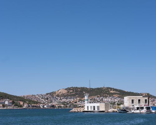 Free A serene view of Foça, İzmir, capturing the coastline, harbor, and buildings under a clear blue sky. Stock Photo