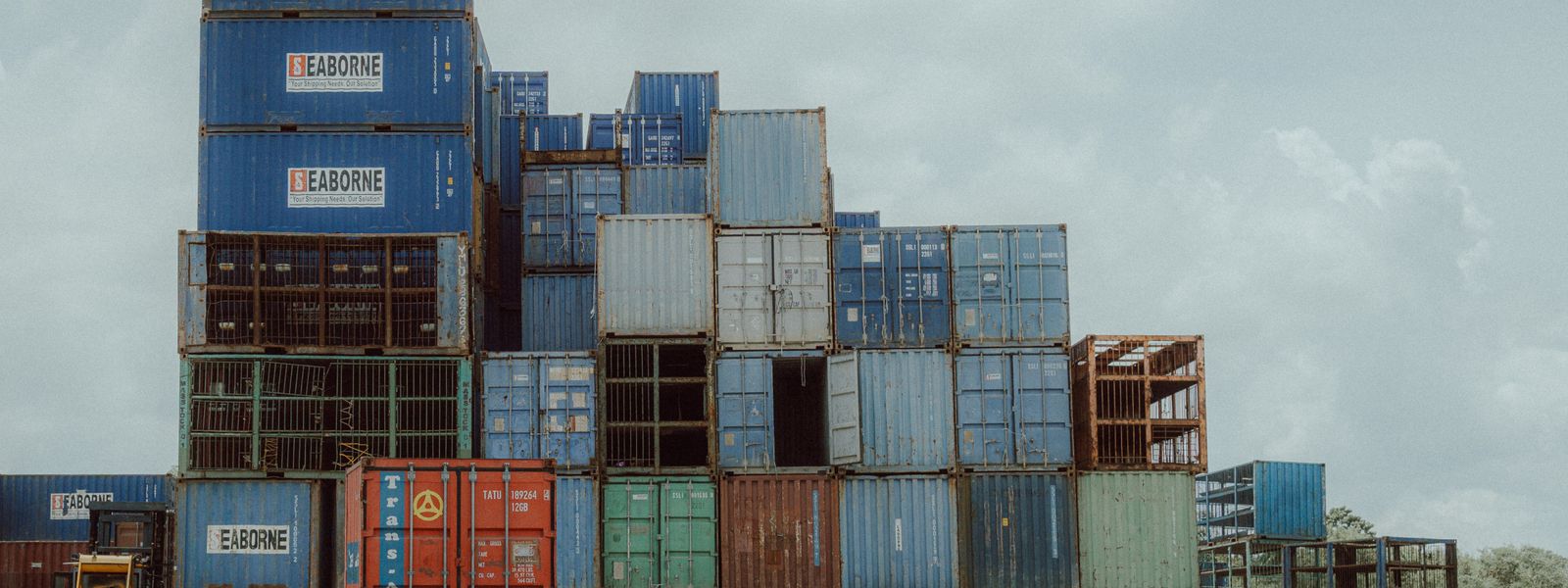 Truck parked beside stacked shipping containers