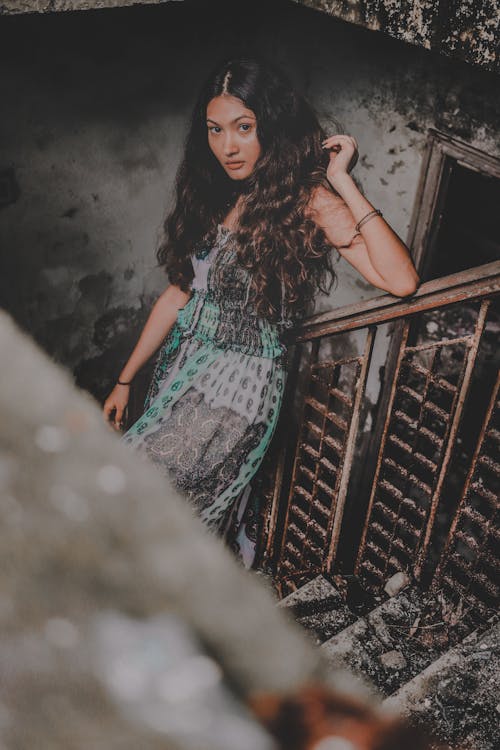 Woman Standing on Stair Steps Inside Building