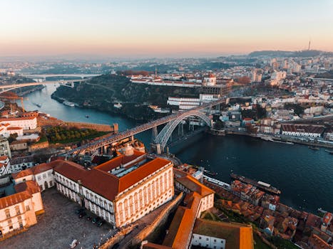 Spectacular aerial shot showcasing Porto's Luís I Bridge and vibrant cityscape during sunset.
