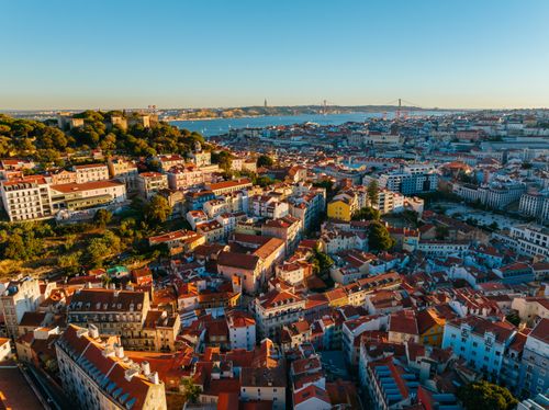 Free Discover the vibrant cityscape of Lisbon, Portugal, captured from above at sunset, showcasing its historic architecture and waterfront. Stock Photo