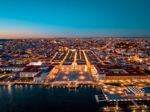 Free A stunning aerial view of Lisbon's illuminated cityscape and waterfront, captured at dusk. Stock Photo