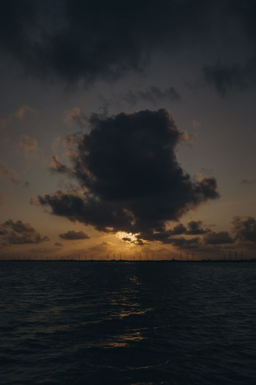Free A scenic sunset with dramatic clouds over water in Kafr El-Shaikh, Egypt. Stock Photo