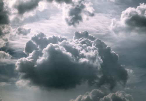 Free A moody and dramatic cloudy sky with sunlight piercing through, creating a stunning visual effect. Stock Photo