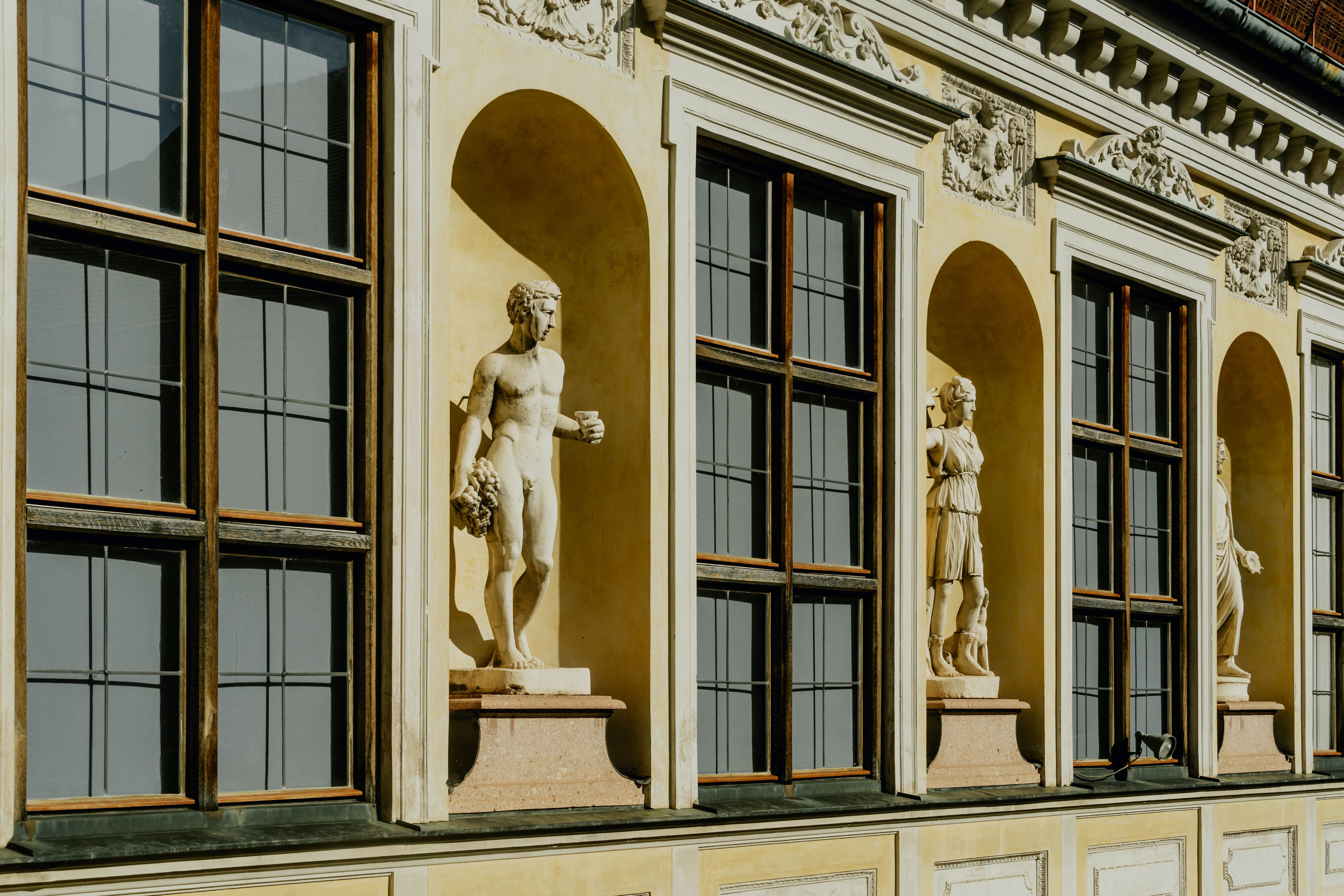 A building with windows and statues on the side · Free Stock Photo