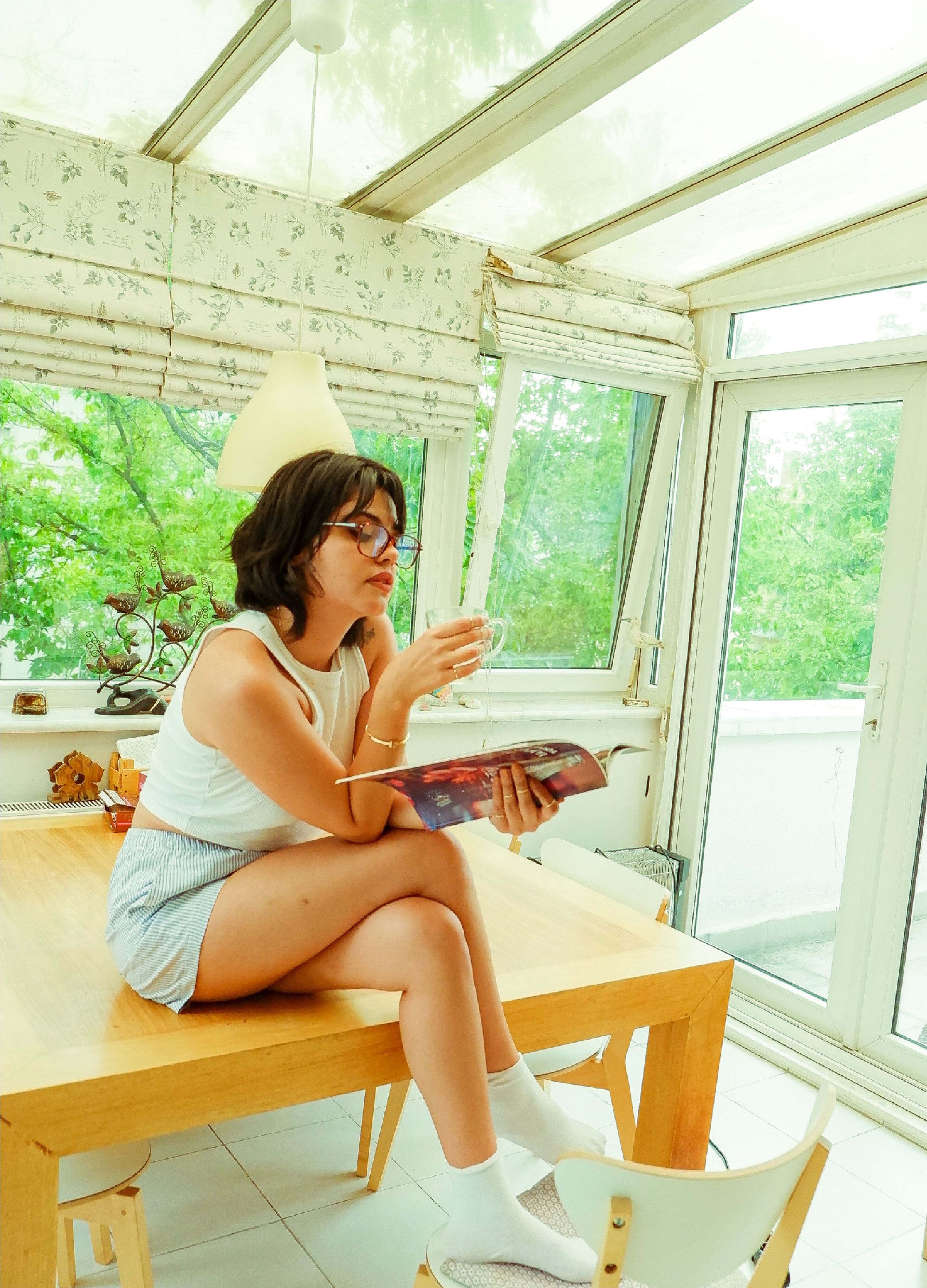 A woman sitting on a table reading a book · Free Stock Photo