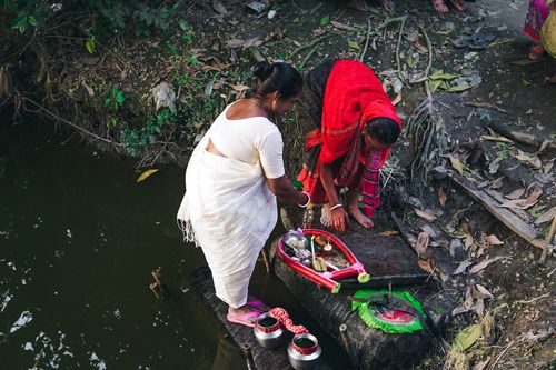 Free Women performing a traditional ritual by a river in Cumilla, Bangladesh. Stock Photo