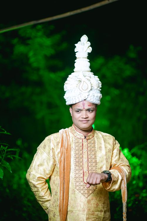 Free Portrait of a groom in traditional Bangladeshi wedding attire with a majestic headpiece outdoors. Stock Photo