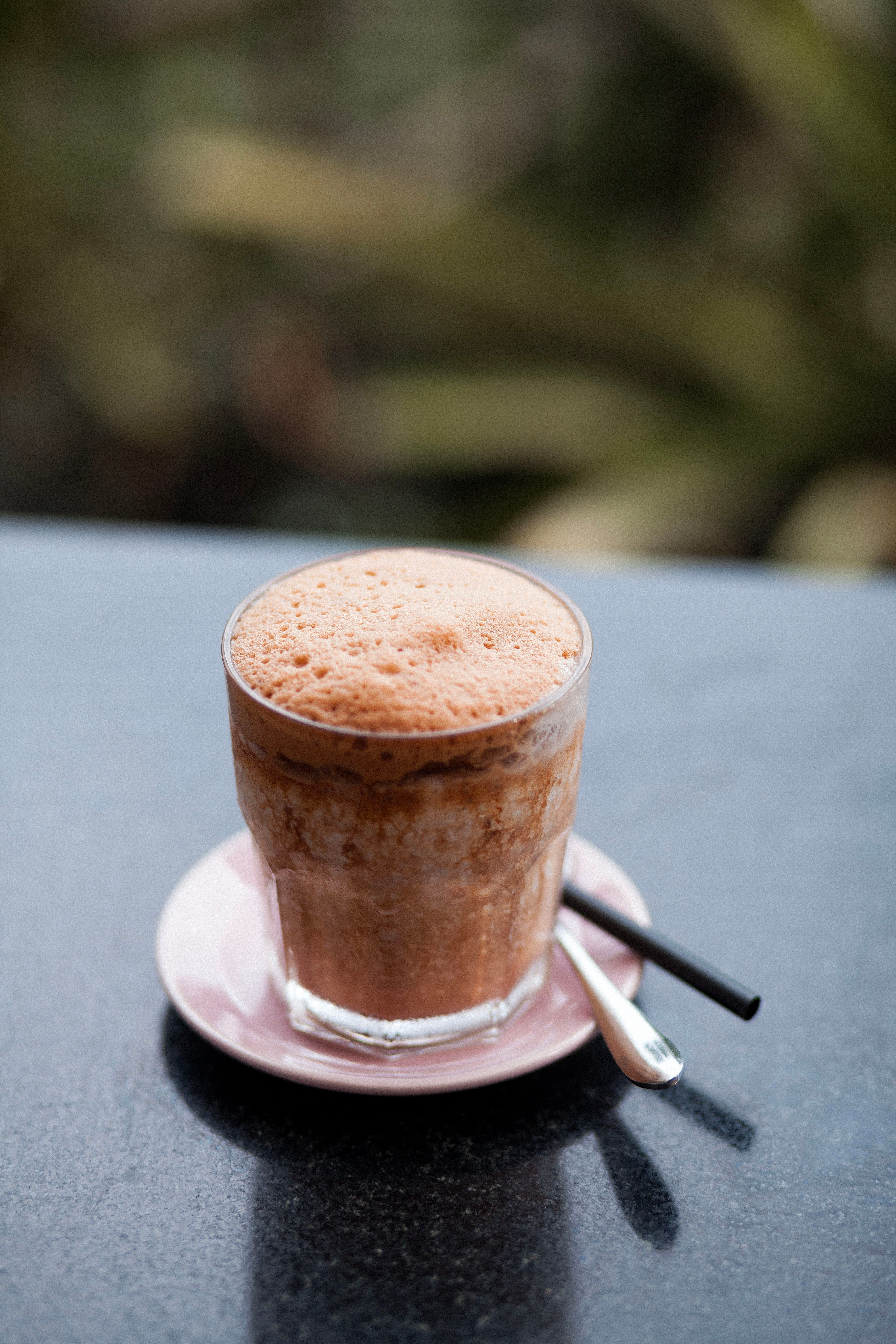 Delicious frothy iced mocha coffee in a glass with a straw, perfect for refreshing mornings.