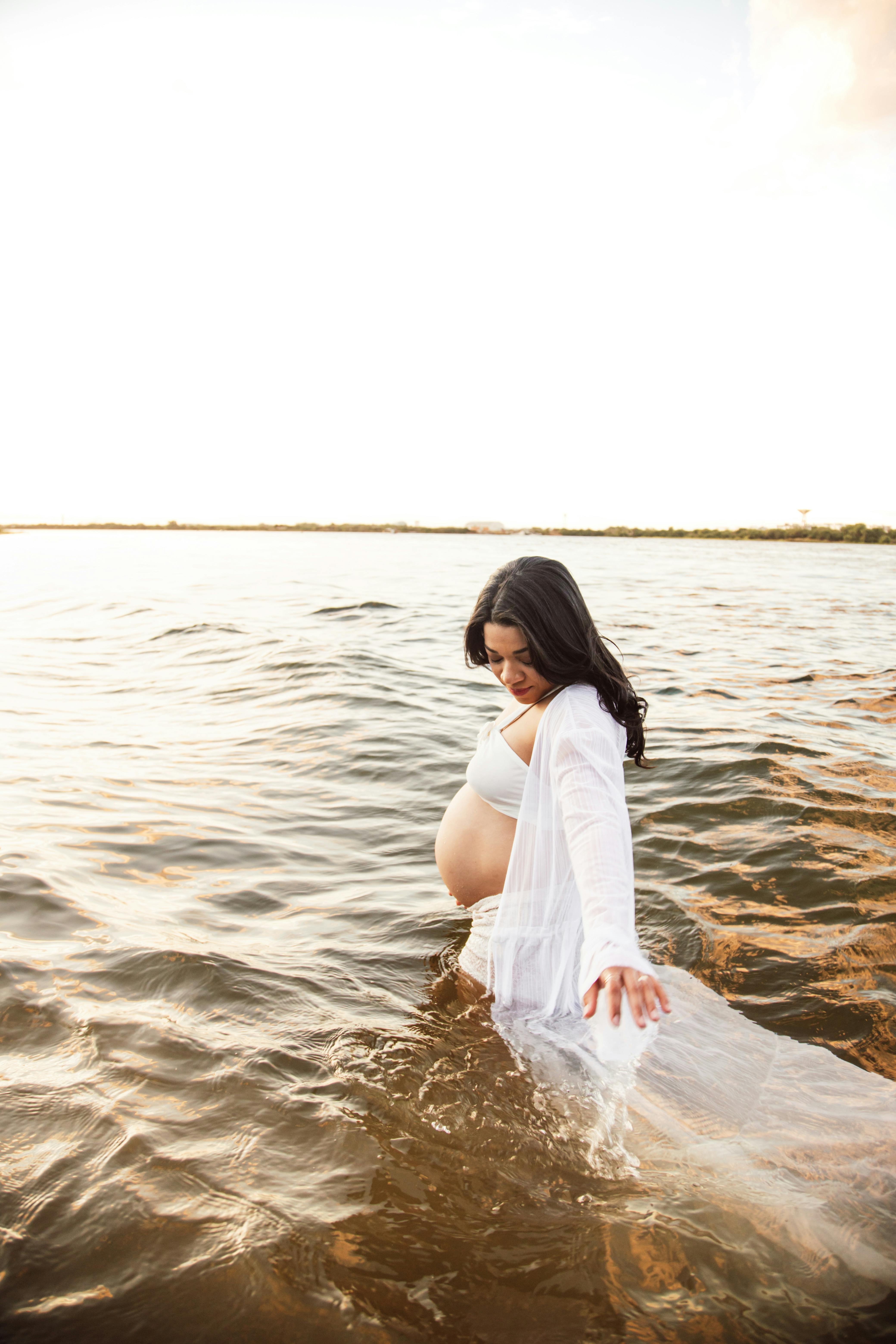 a pregnant woman is standing in the water