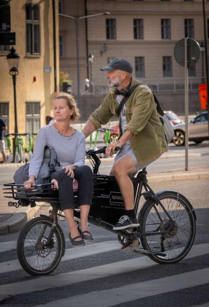 Two people riding a cargo bike through town — photo by Lorenzo Manera on Pexels