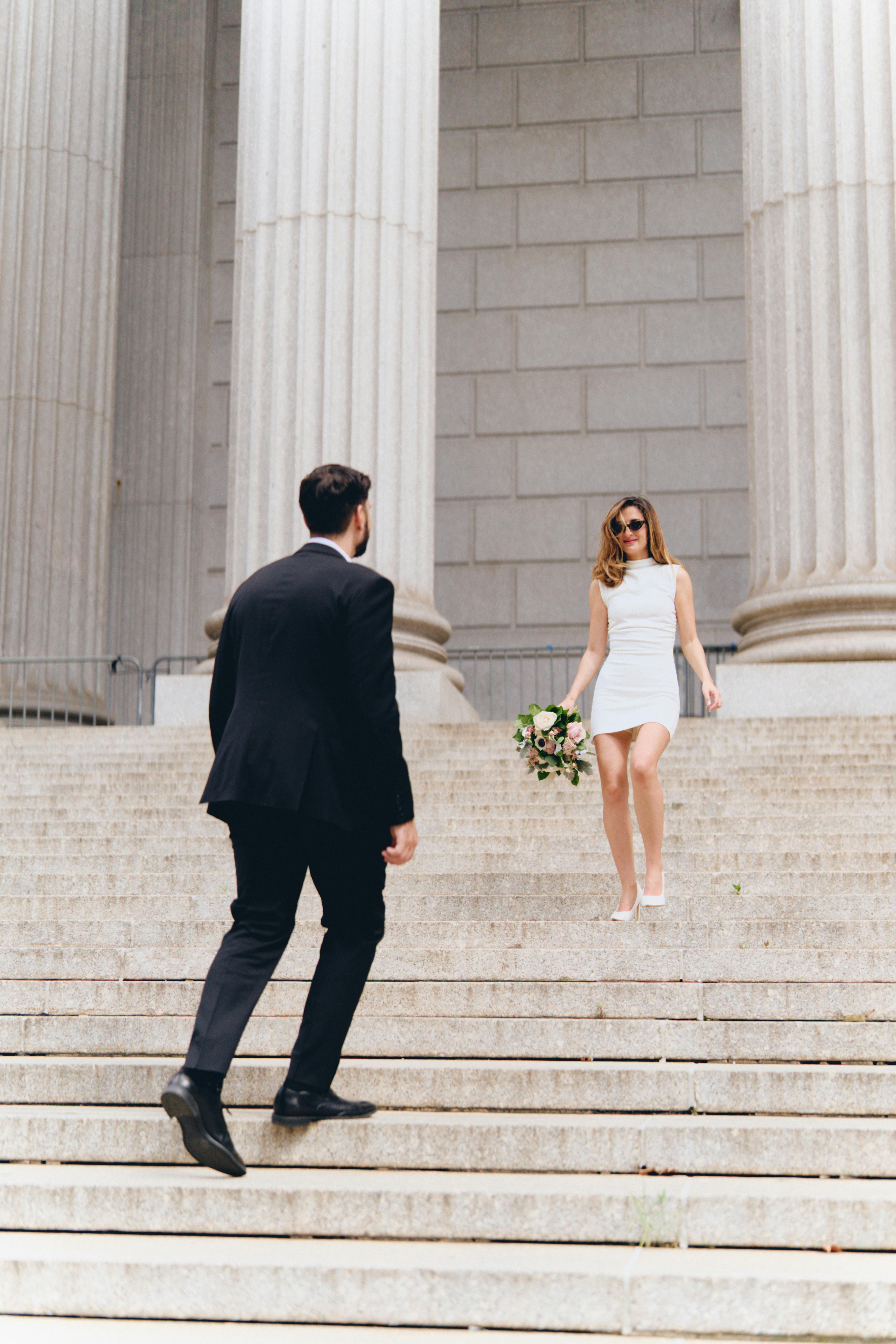 a bride and groom walking down the steps of a building