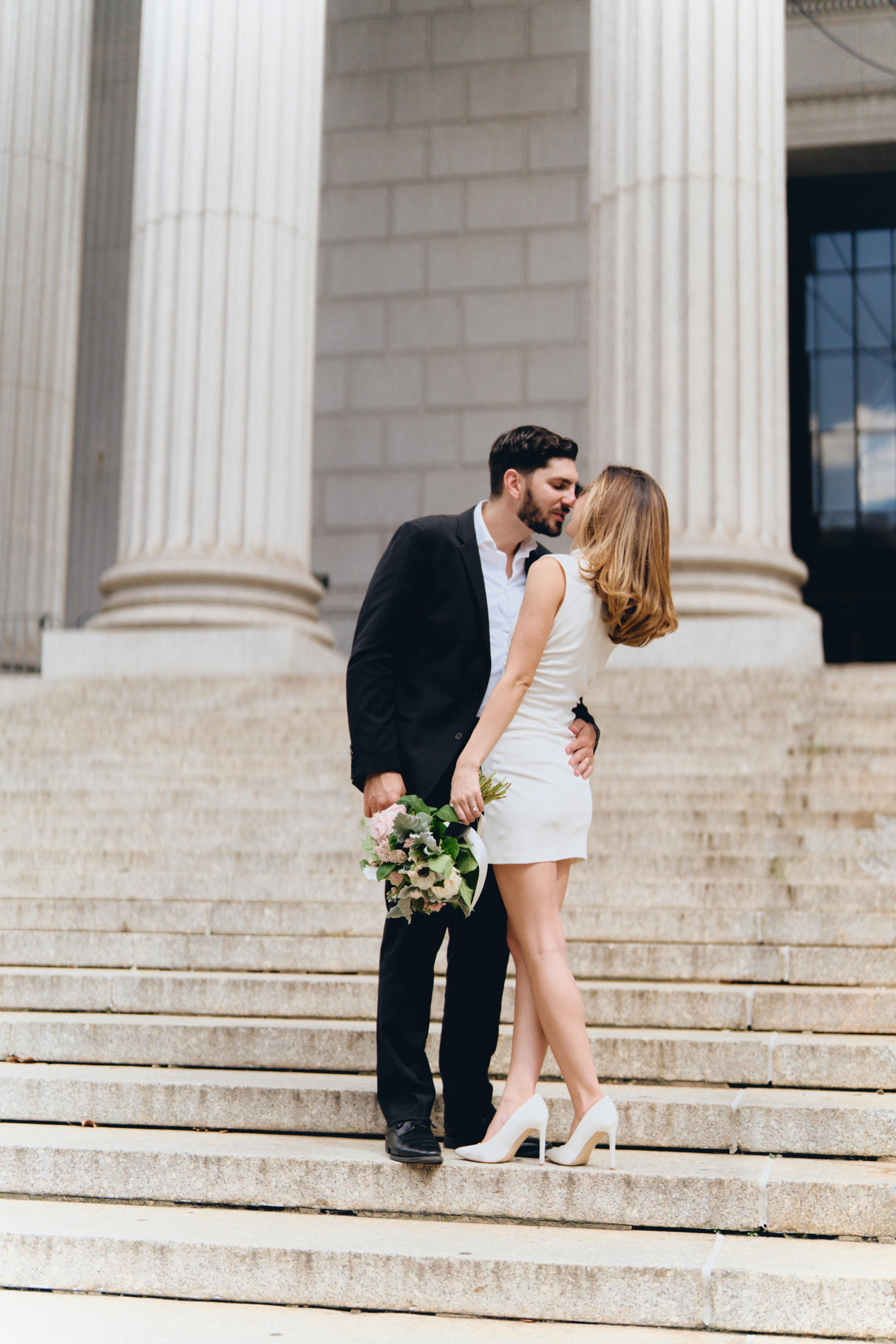 a bride and groom standing on the steps of a building