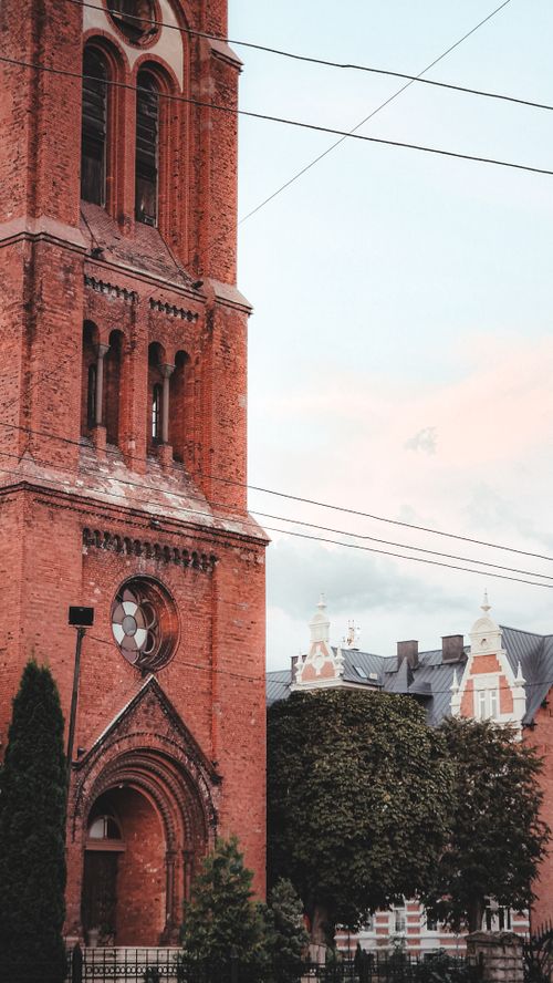 Free Charming view of a brick tower and traditional architecture in a European town, ideal for travel imagery. Stock Photo