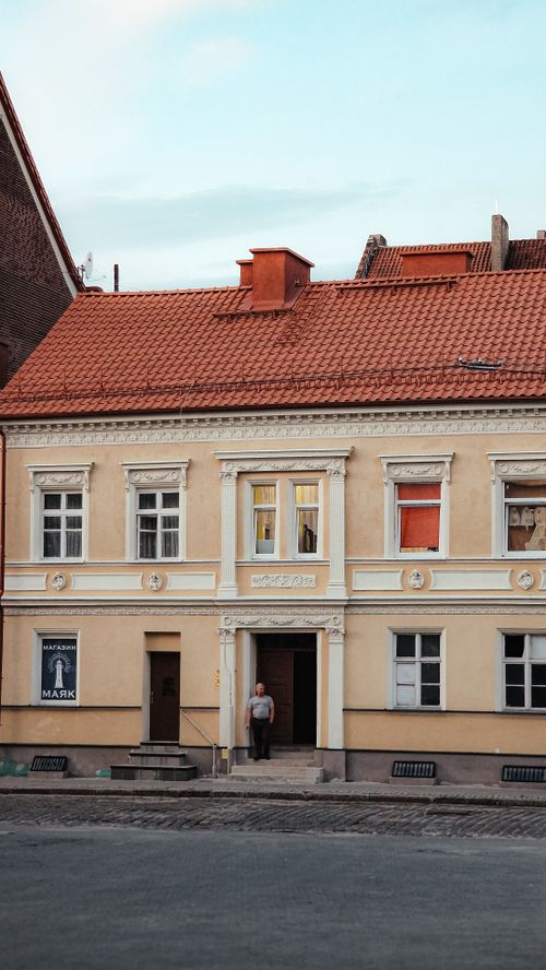 Free A charming traditional townhouse with classic architecture and a person standing at the entrance. Stock Photo