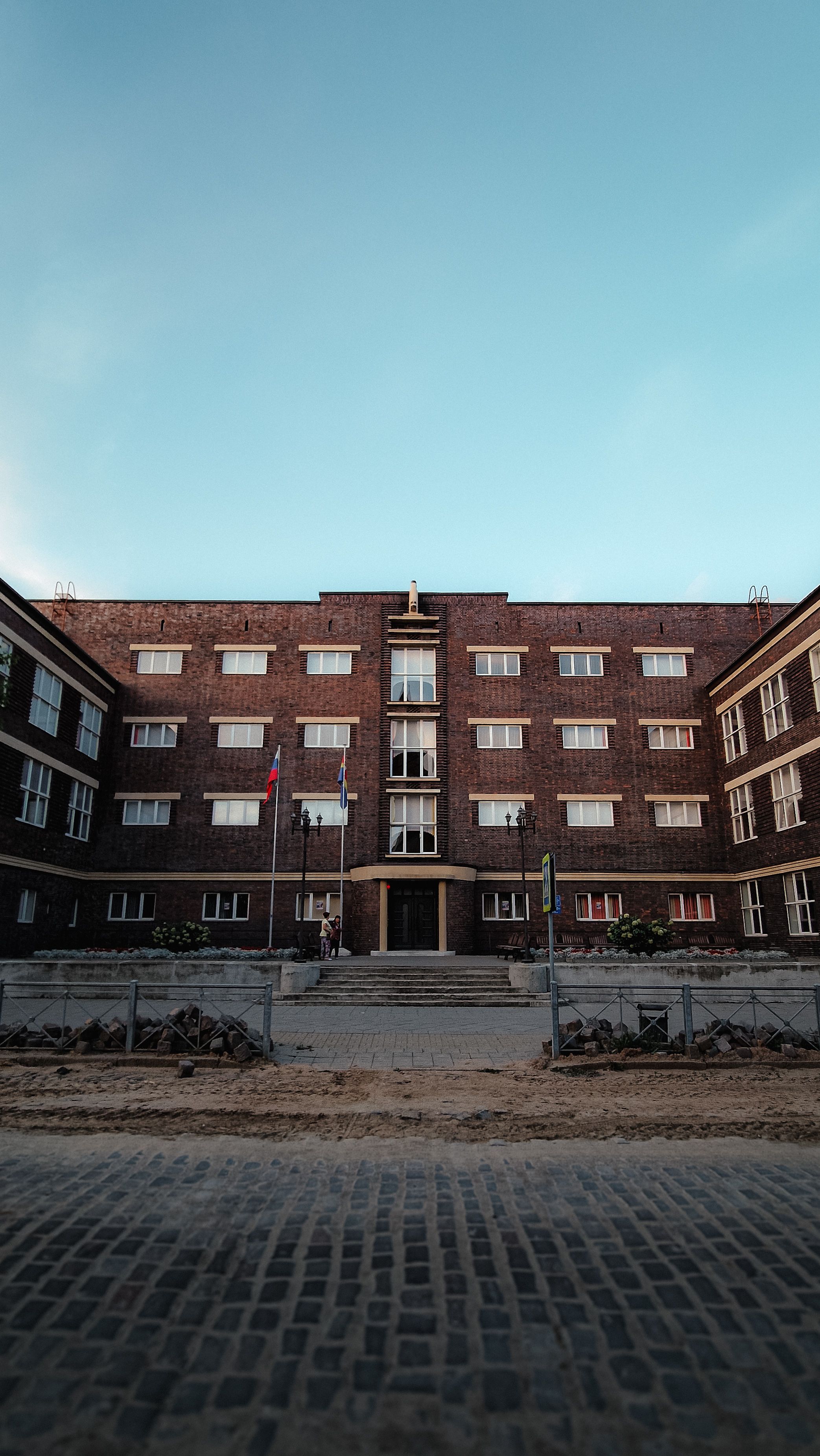A large brick building with windows and a clock · Free Stock Photo