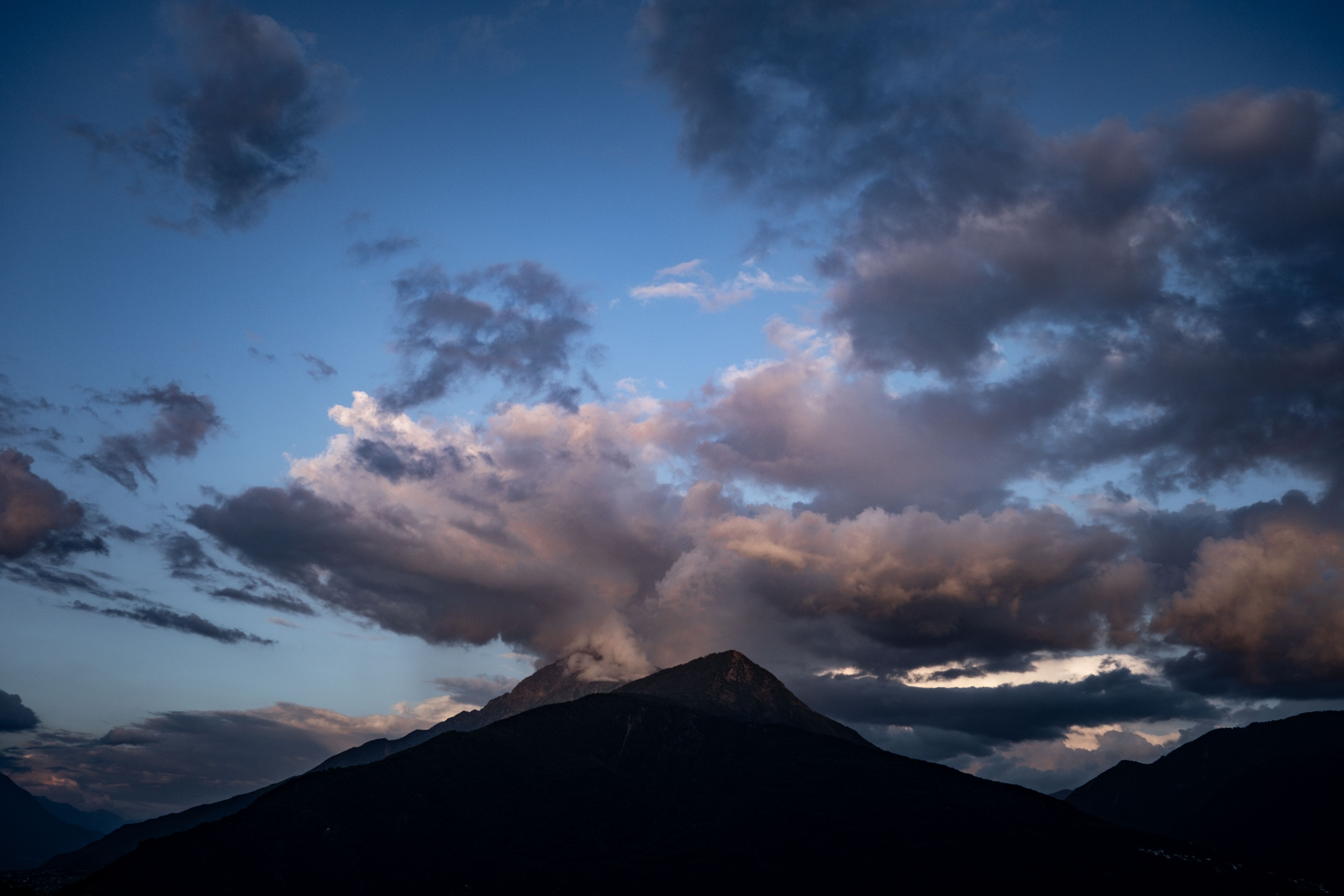 A mountain with clouds and a dark sky · Free Stock Photo