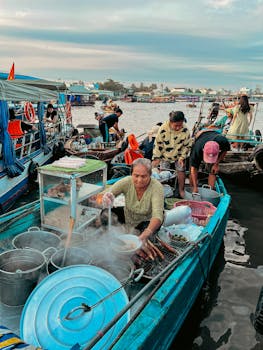 A lively floating market with vendors selling fresh fish and other goods on small boats.