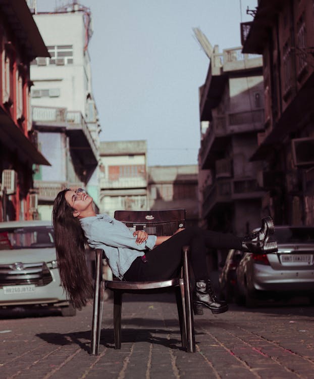 Woman Sitting On A Chair In The Street