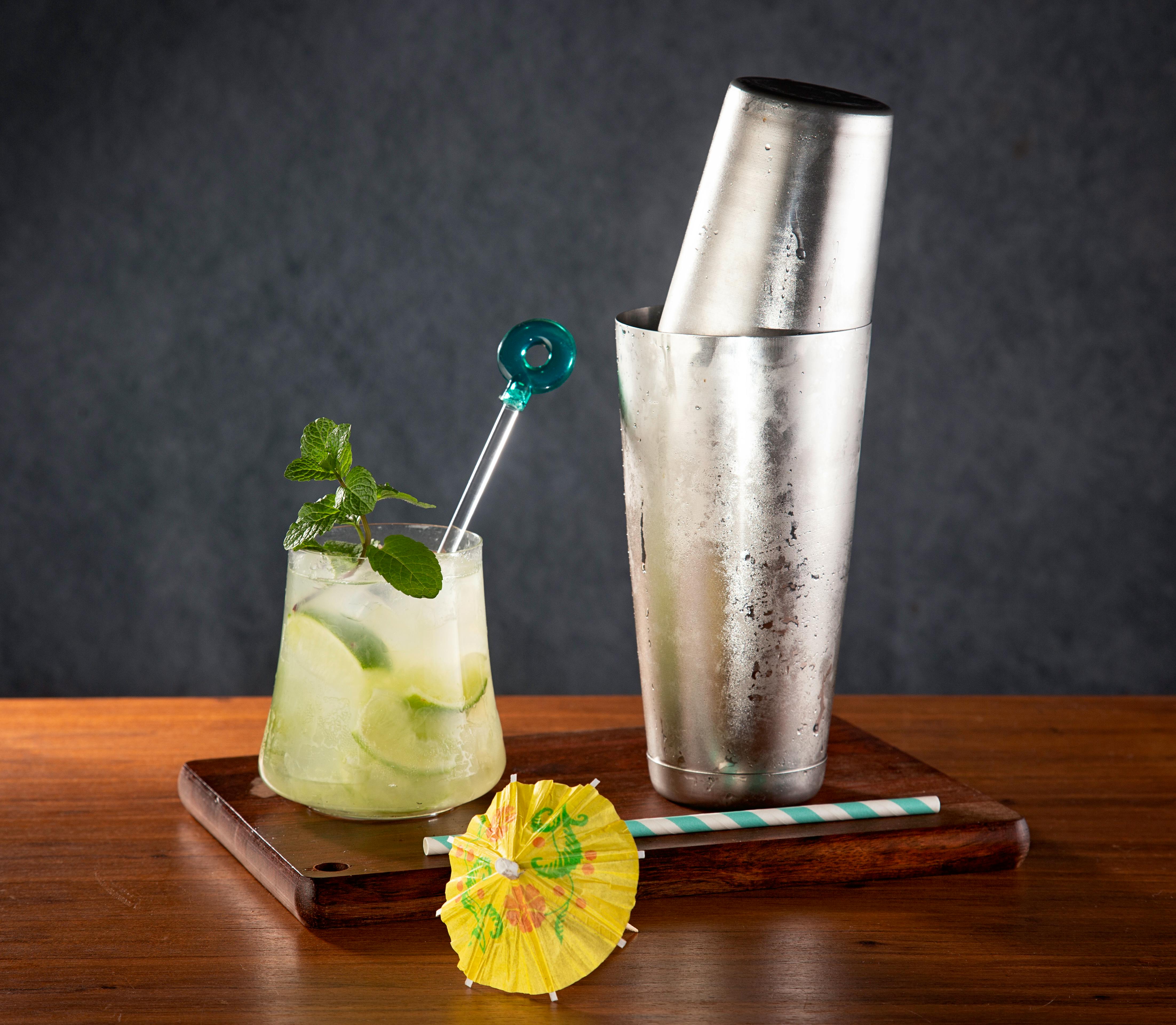 fresh limes, lemons, and mint next to a cocktail shaker - what to mix with vodka