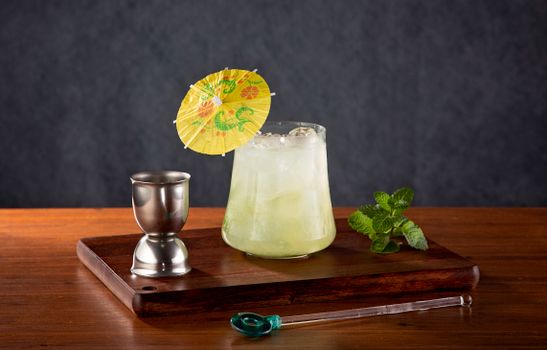 A refreshing cocktail with mint leaves and a decorative umbrella, perfect for summer.