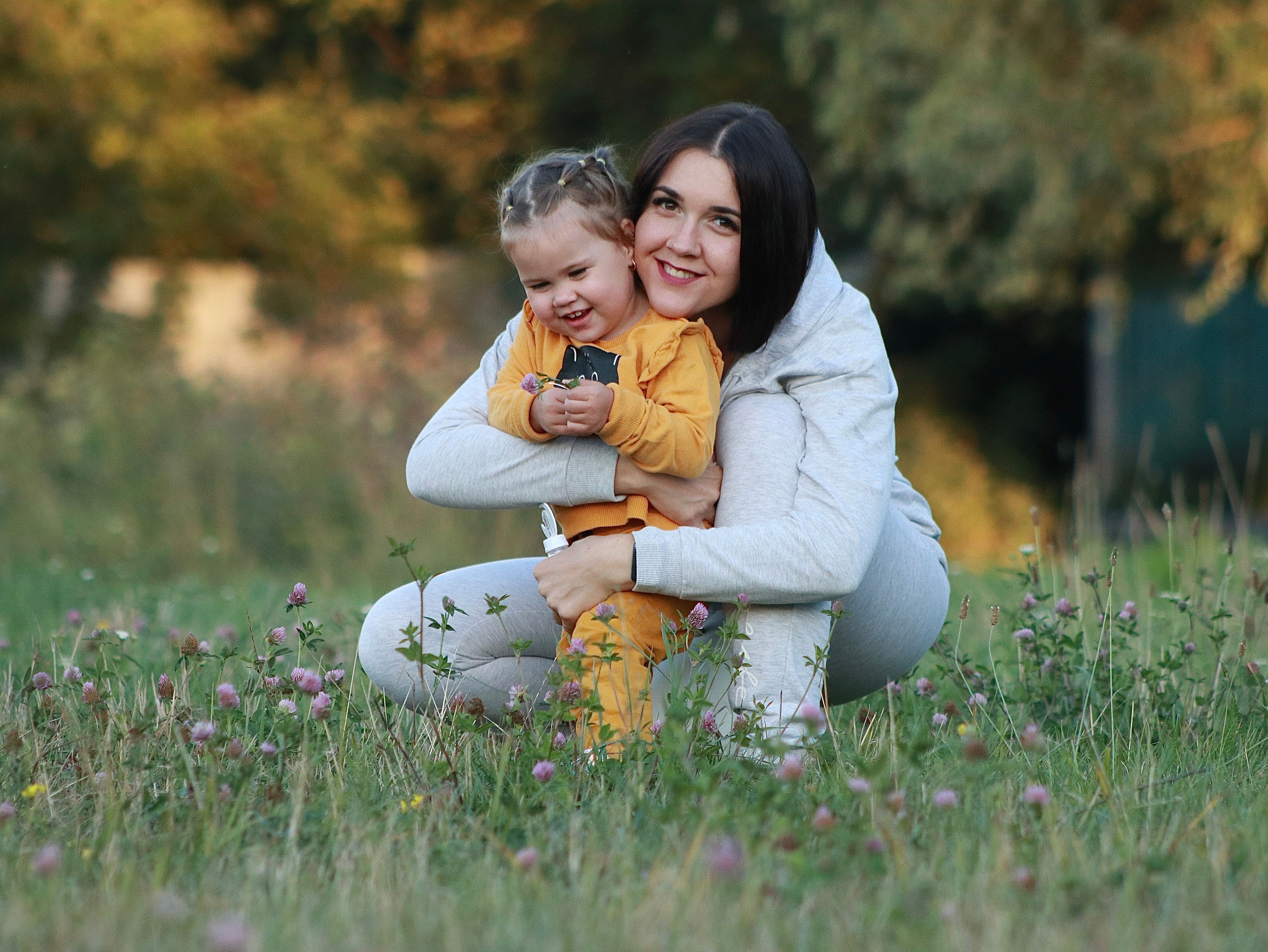 A woman and child are sitting in a field · Free Stock Photo
