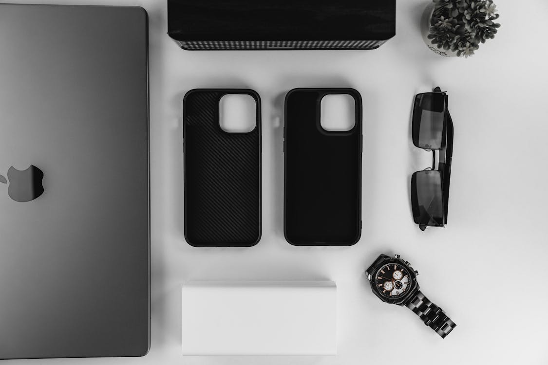 Sustainable phone case placed on a table with laptop, watch, sunglasses
