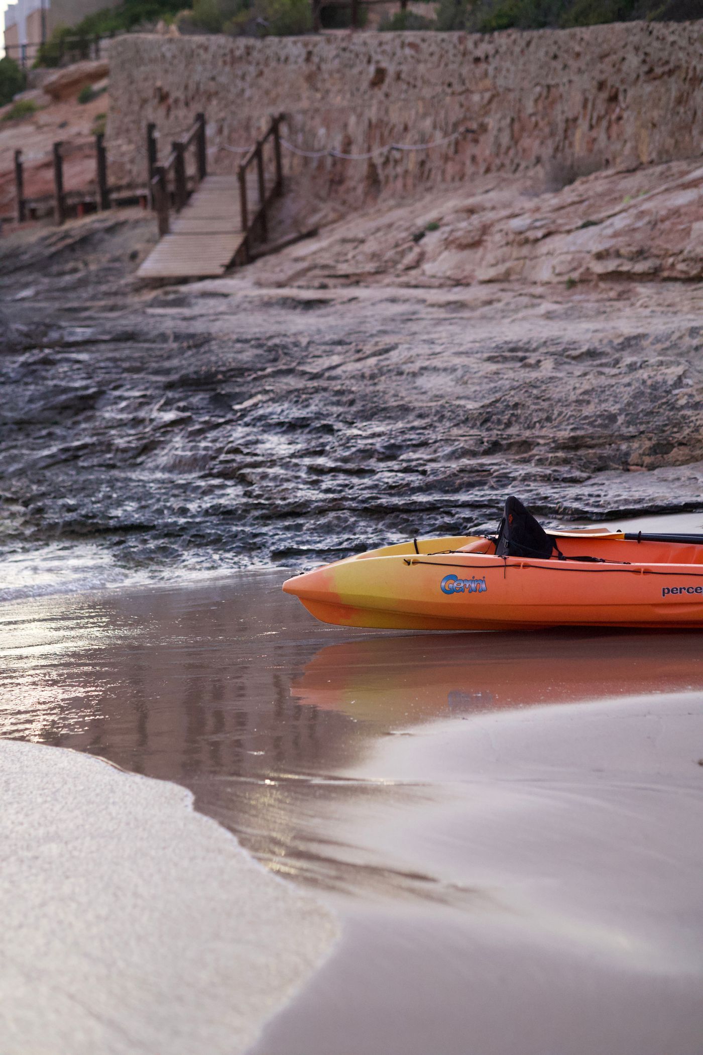 Kayak resting beside a quiet coastal shoreline