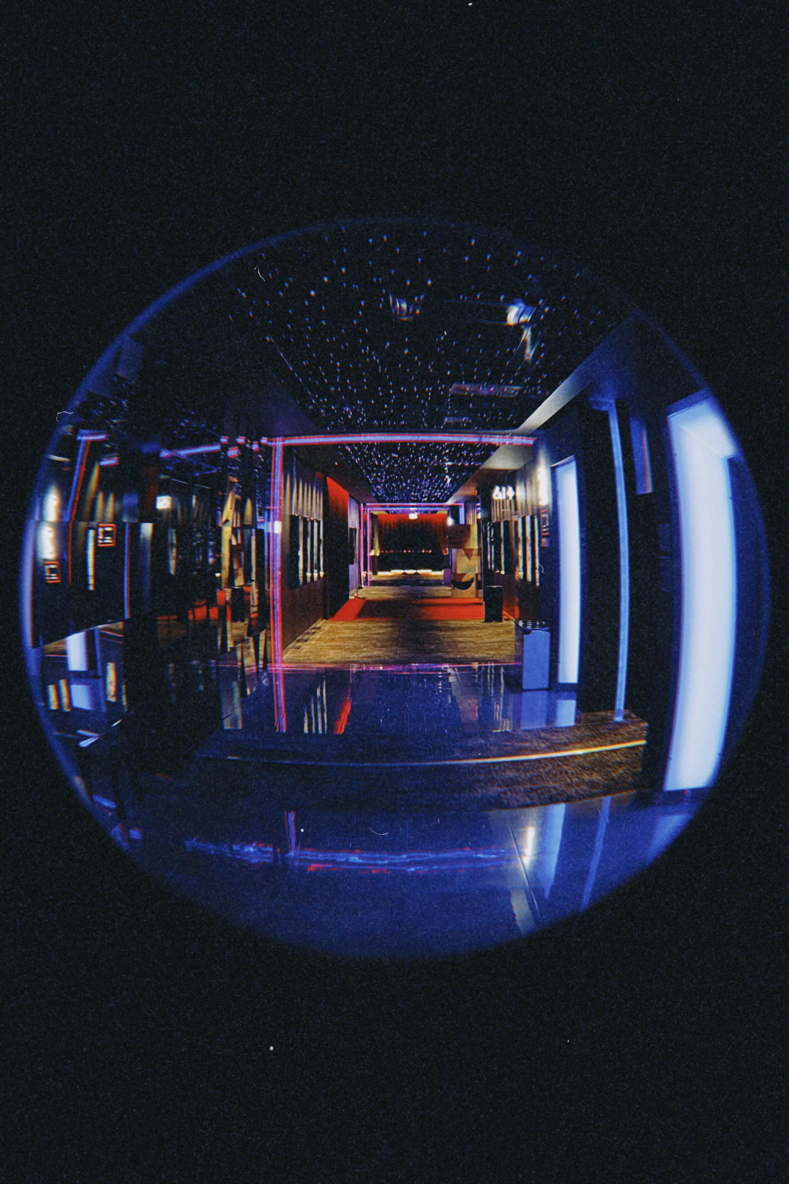 A mesmerizing fisheye lens capture of a dimly lit corridor in Poznań's interior.