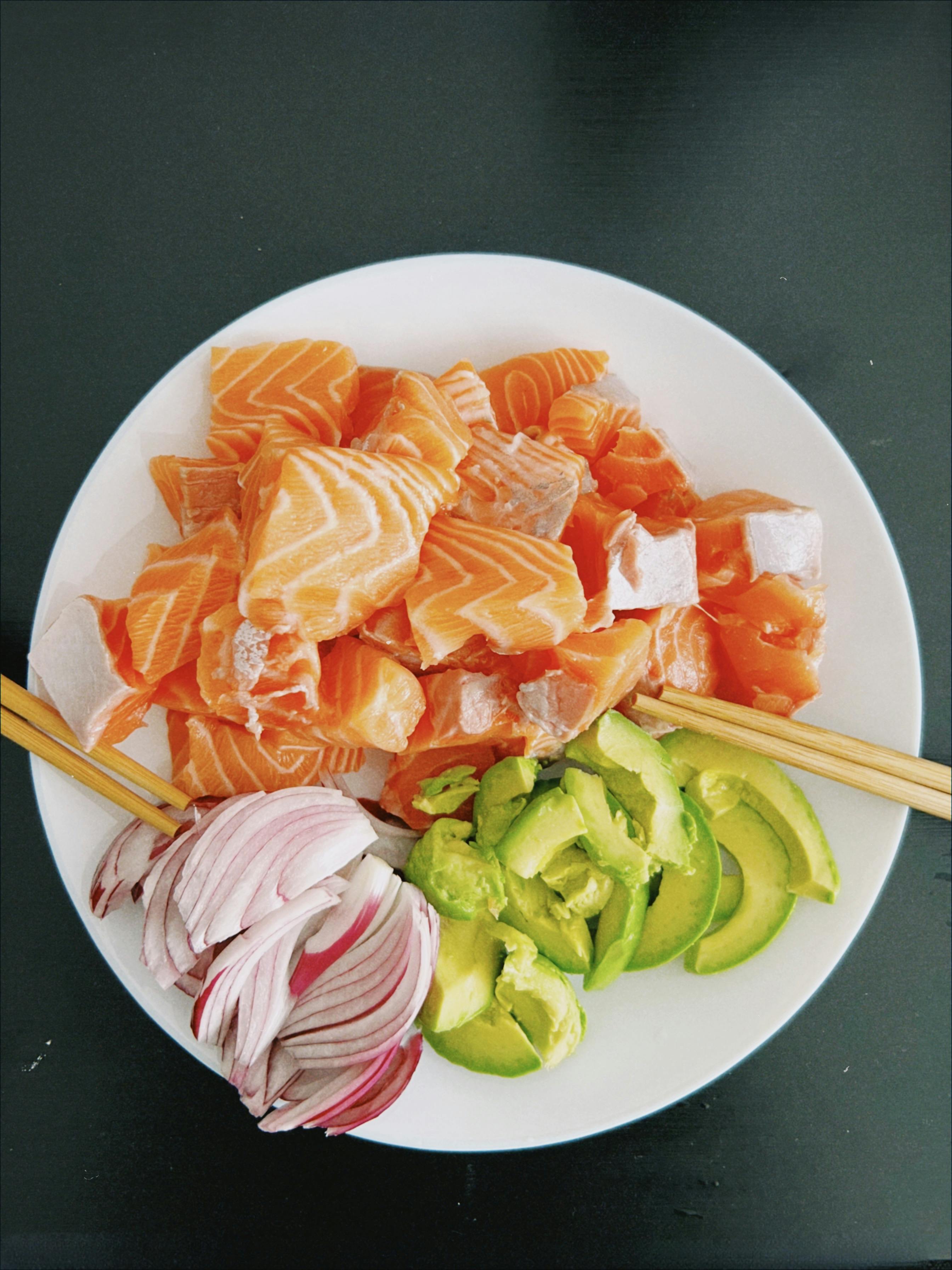 a plate with salmon avocado and onions