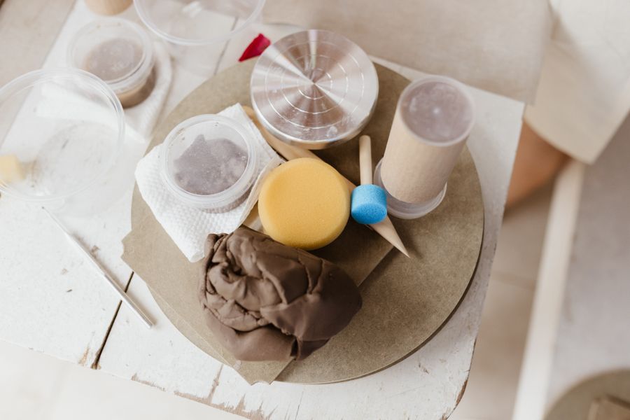 Clay, sponges and throwing tools on a bench
