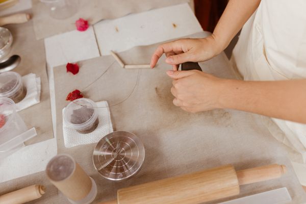 Hands shaping handmade paper with tools, photo by Jonathan Borba on Pexels