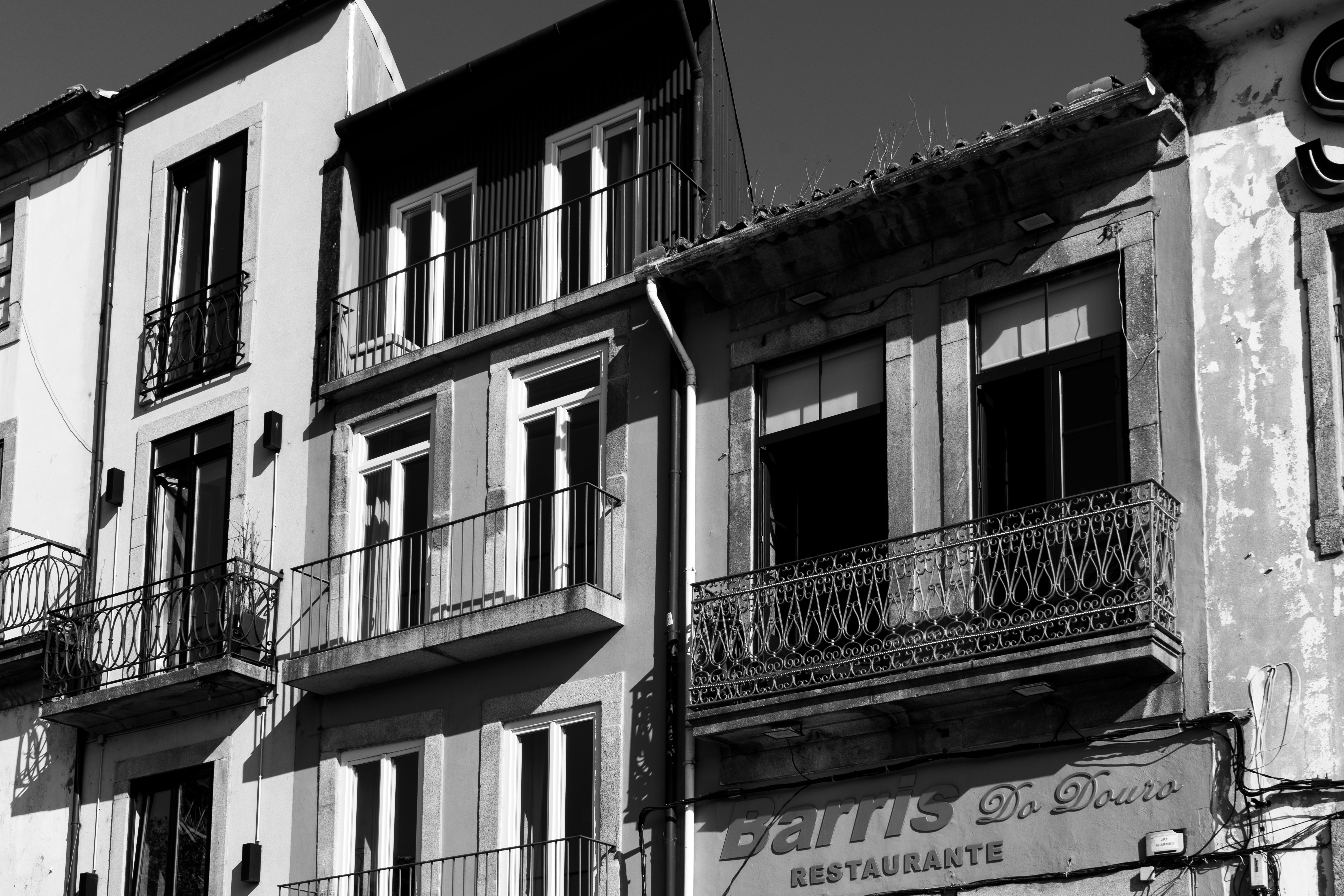Black and white photograph showcasing traditional facades in Porto, Portugal.
