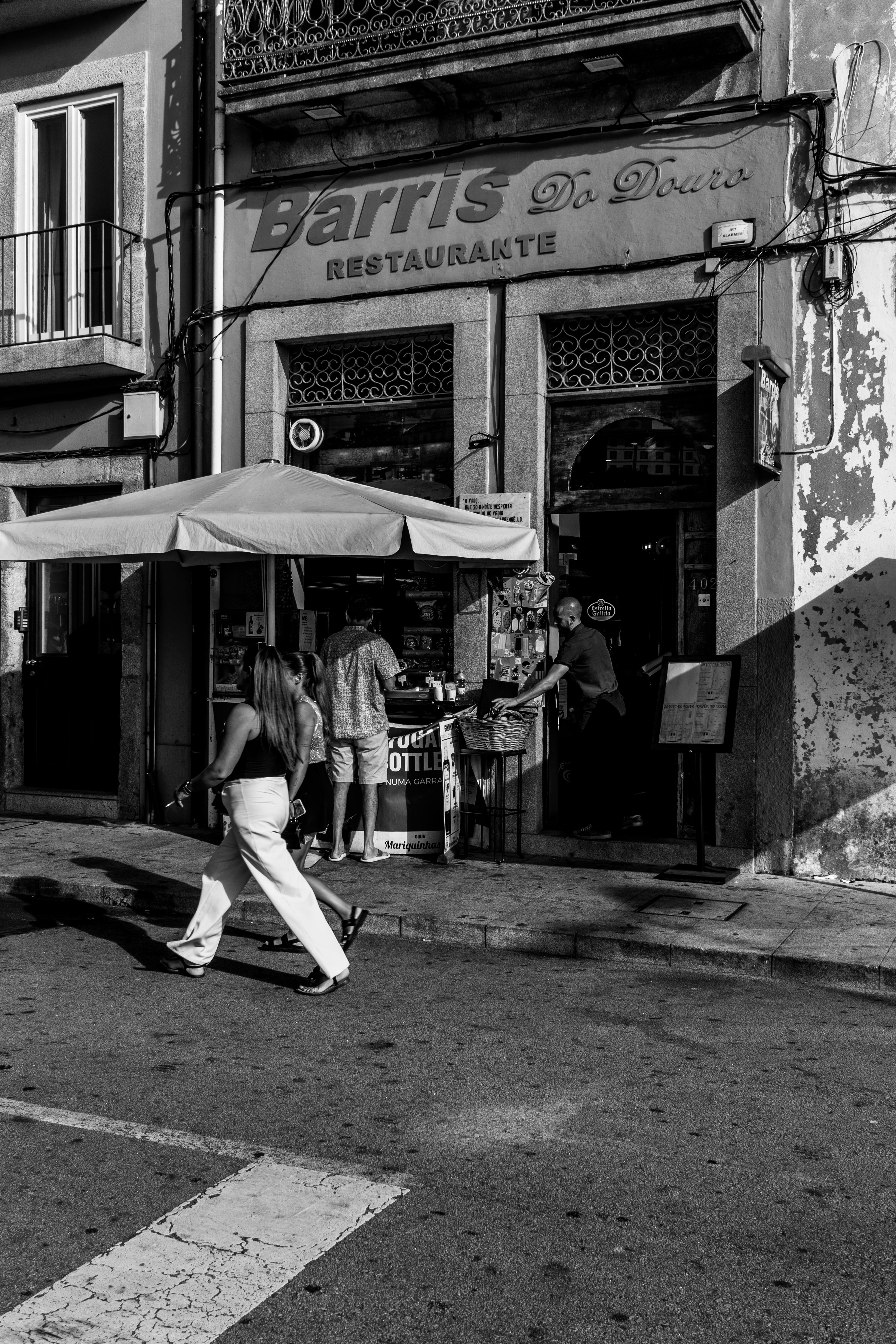 Black and white street photo capturing daily life in Porto, Portugal.