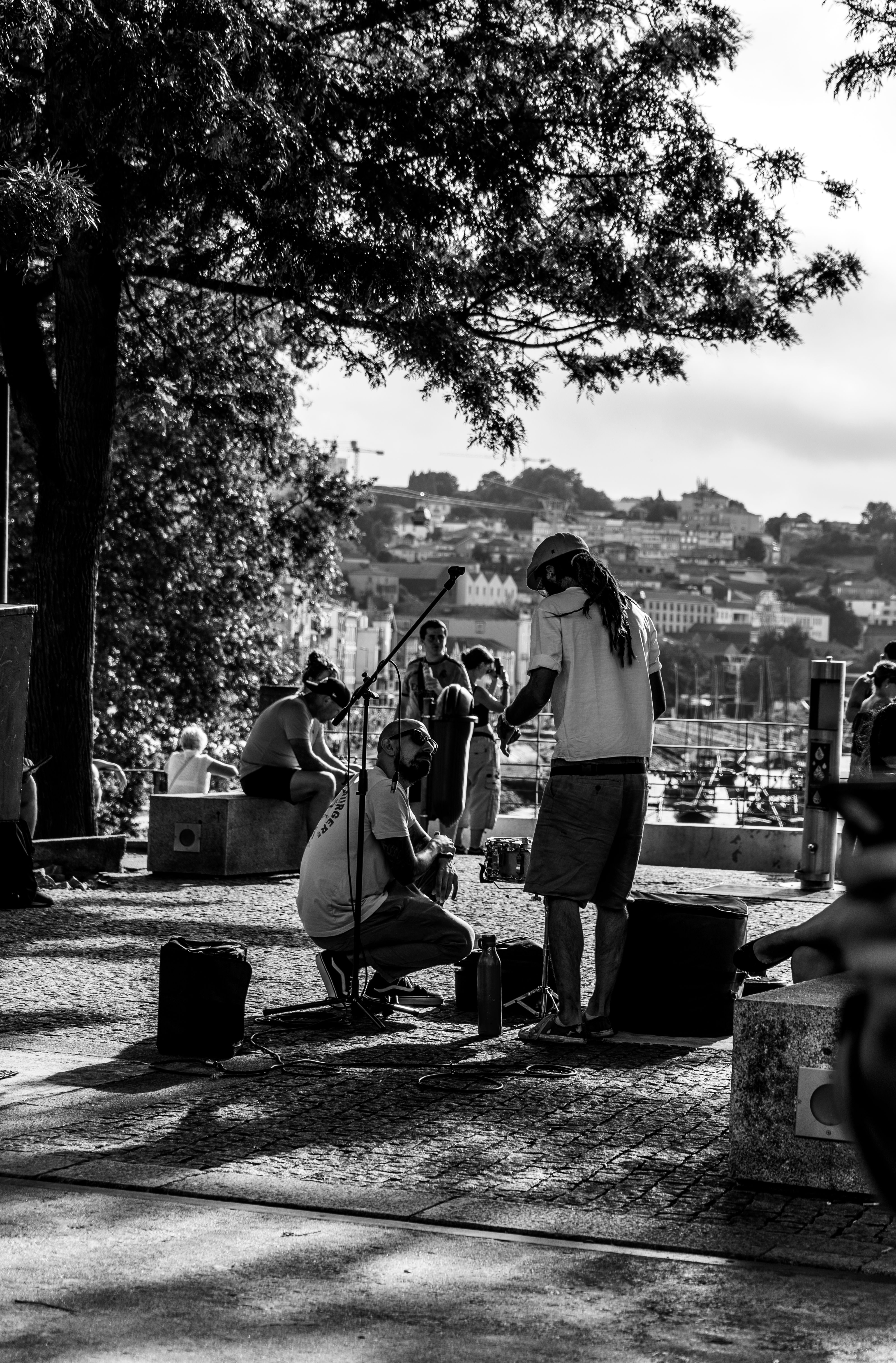Black and white photo of street musicians performing in Porto with a guitar, capturing local culture and ambiance.