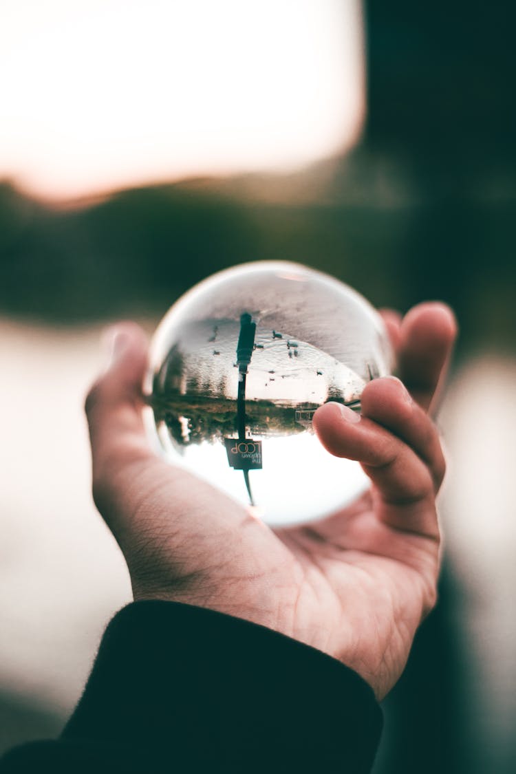 Person Holding Glass Ball