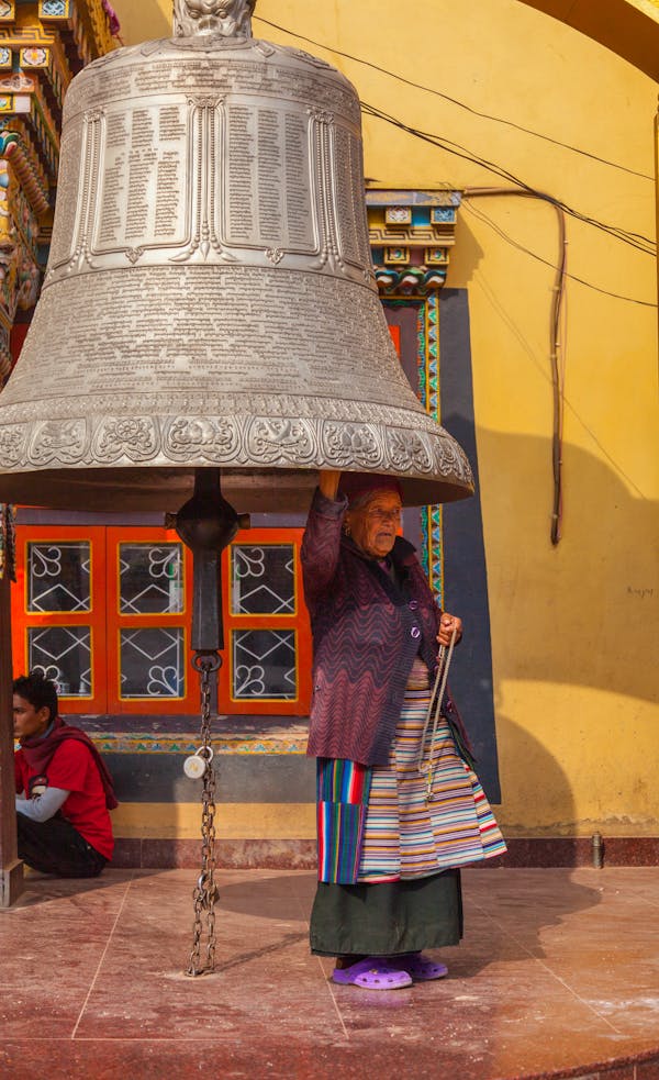 Woman Standing Under Huge Bell