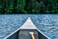 在风景优美的湖泊上，宁静地乘坐独木舟，四周环绕着郁郁葱葱的森林