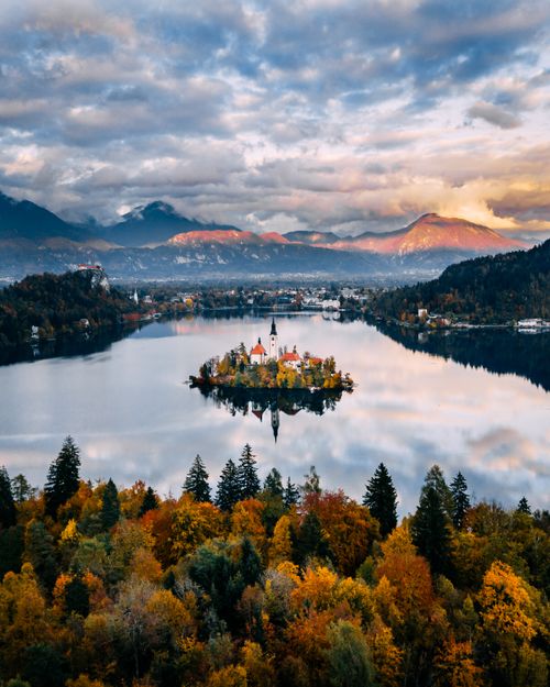 Free Stunning aerial view of Lake Bled, Slovenia during autumn with colorful foliage and serene waters. Stock Photo