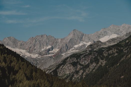 Breathtaking view of alpine mountains with snow under a clear blue sky.