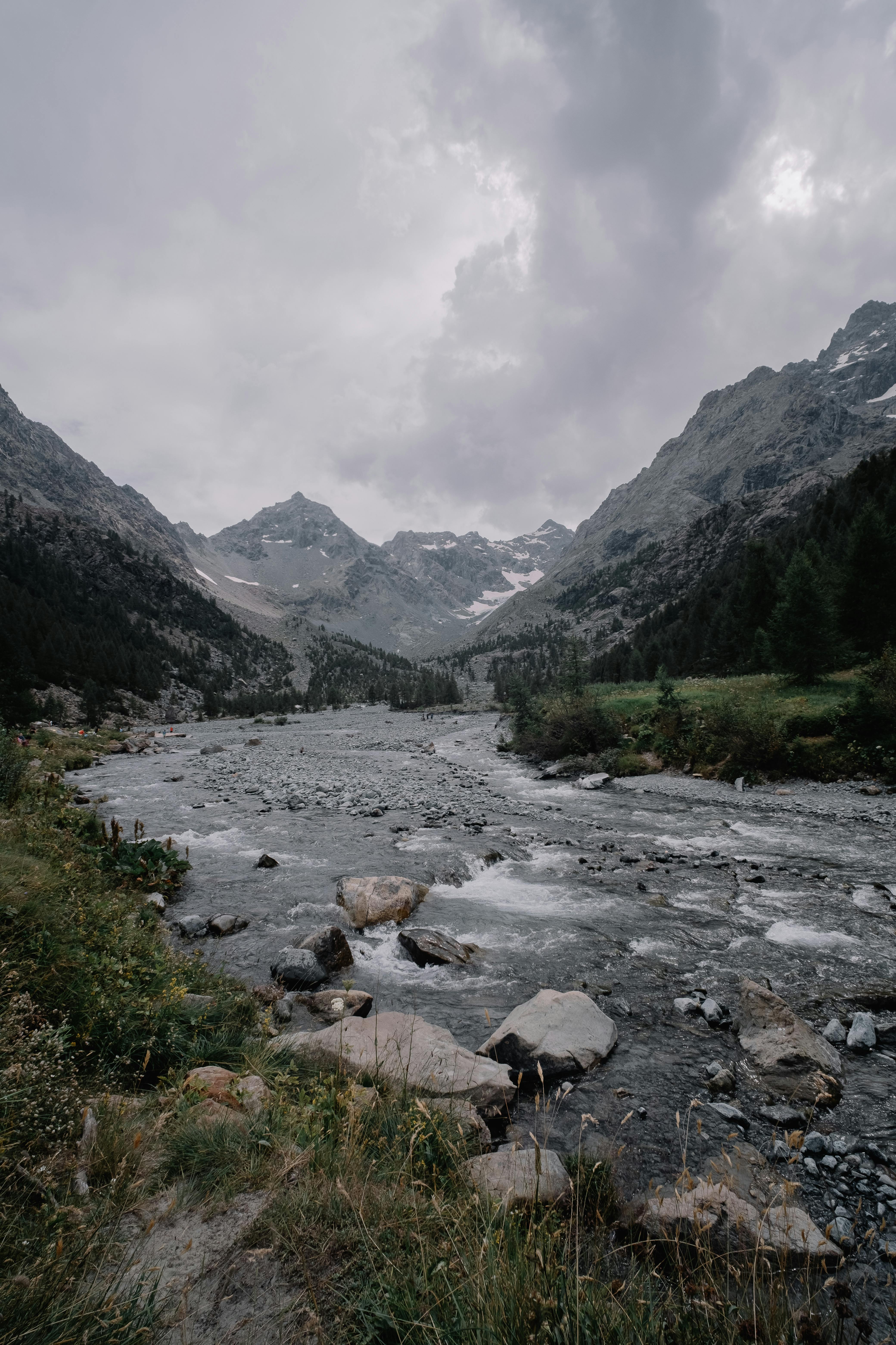 a river in the mountains with rocks and trees