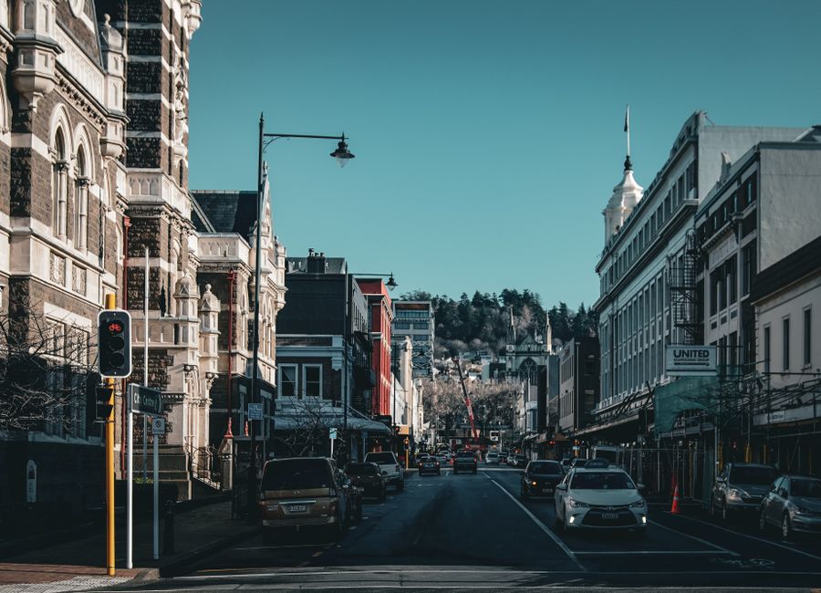 Historic urban street view in Dunedin with classic architecture and light traffic.