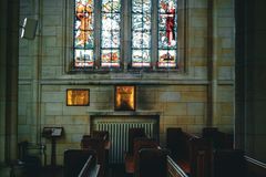 A serene church interior featuring stained glass windows and wooden pews, creating a peaceful ambiance.