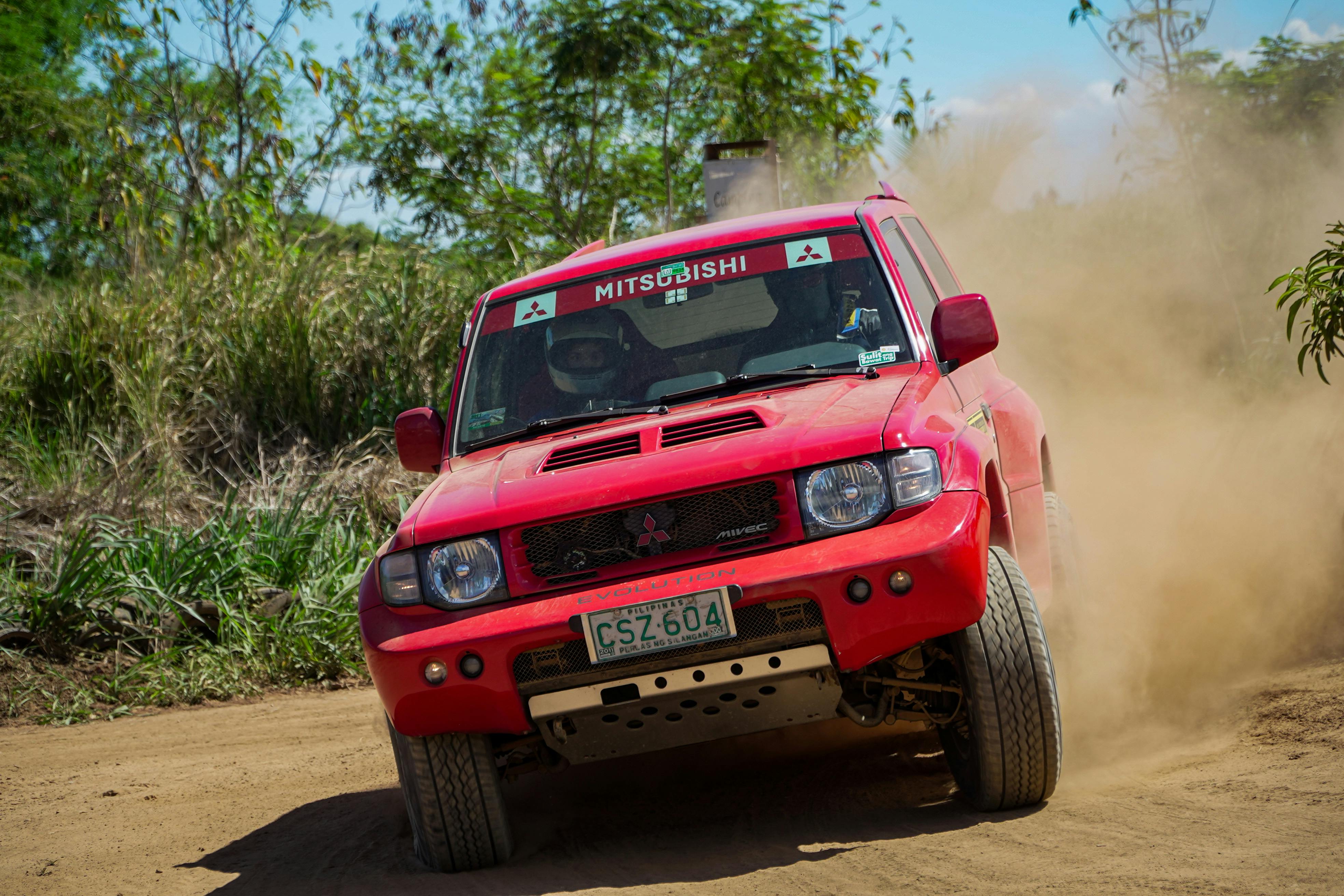 Red SUV kicks up dust in an exciting off-road race in Baras, Philippines.