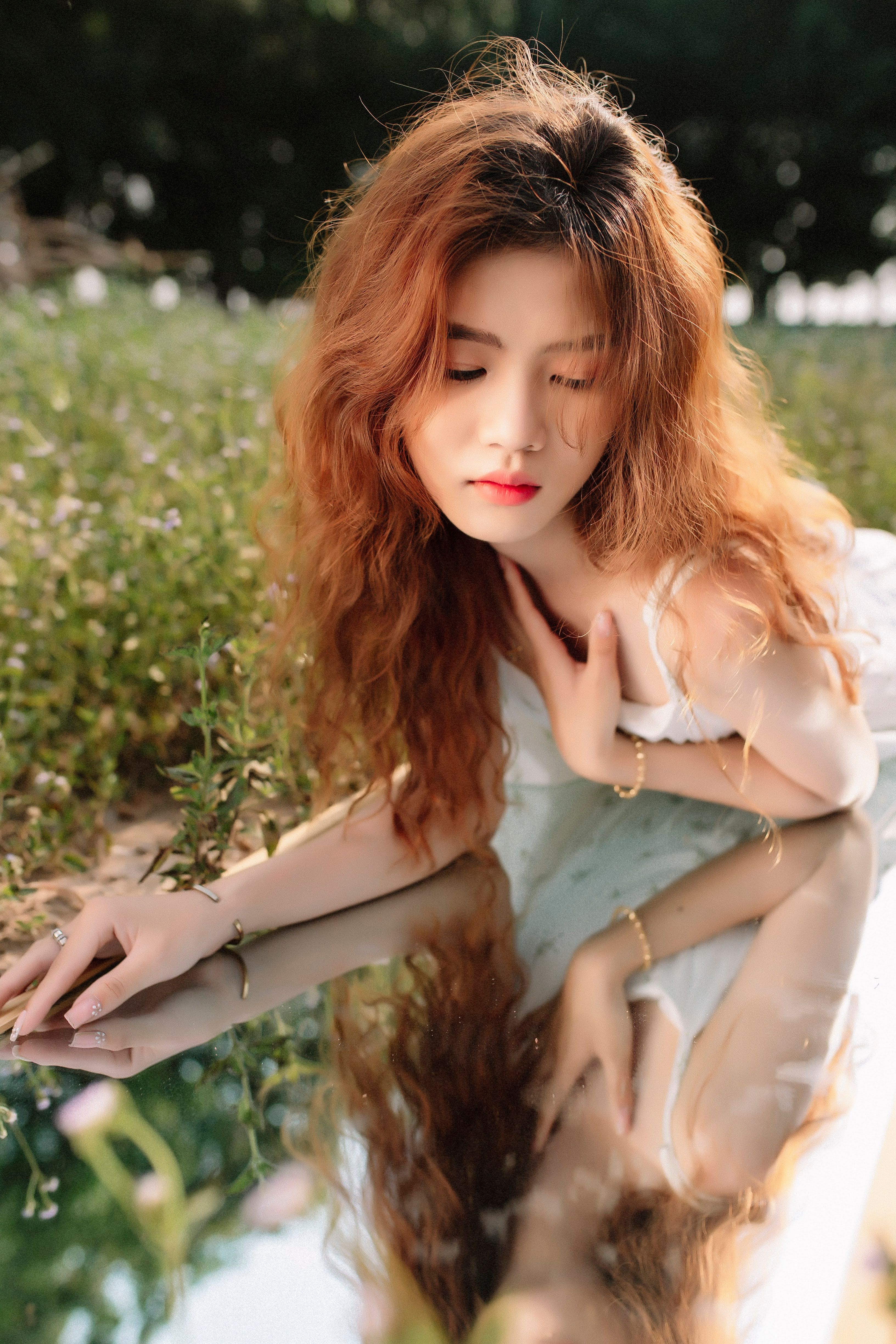 A woman with long red hair laying on the grass · Free Stock Photo