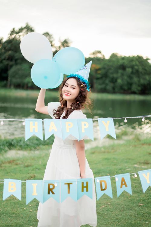 Free A young woman celebrates her birthday outdoors with balloons and decor. Stock Photo