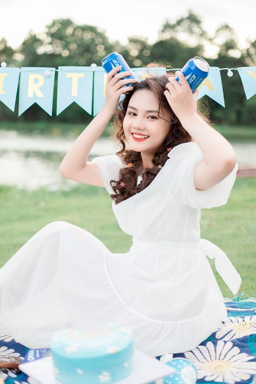 Free Young woman having fun outdoors at a festive picnic by the lake. Stock Photo